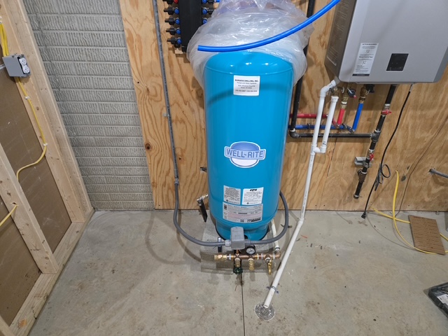 Blue well pressure tank installed with water system controls